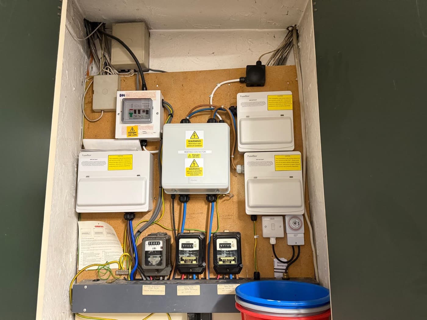 Meter cupboard with consumer units, meters and an alarm panel mounted on one tidy board
